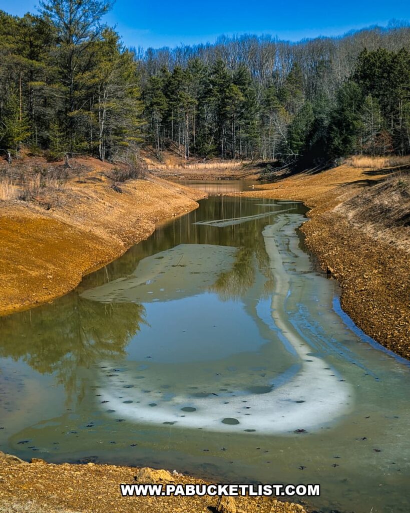 View of a partially frozen pond and earthen basin near the ruins of the ghost town of Scotia in the Scotia Barrens of Centre County, Pennsylvania.