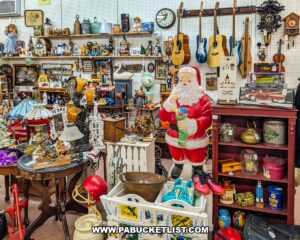 Vendor booth filled with vintage collectibles, guitars, lamps, toys, and a large Santa Claus figure at Fayetteville Antique & Craft Mall in Franklin County, Pennsylvania.