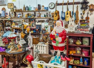 Exploring Fayetteville Antique Mall in Franklin County Vendor booth filled with vintage collectibles, guitars, lamps, toys, and a large Santa Claus figure at Fayetteville Antique & Craft Mall in Franklin County, Pennsylvania.