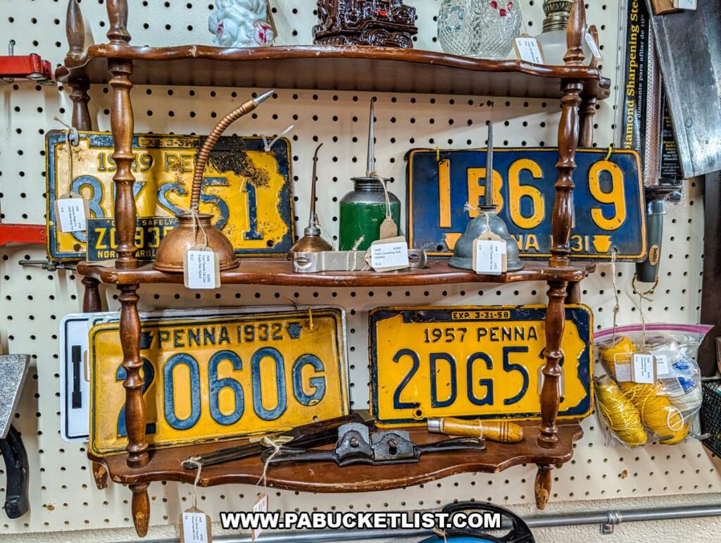 Vintage Pennsylvania license plates and antique oil cans displayed with old tools at Fayetteville Antique & Craft Mall in Franklin County, Pennsylvania.