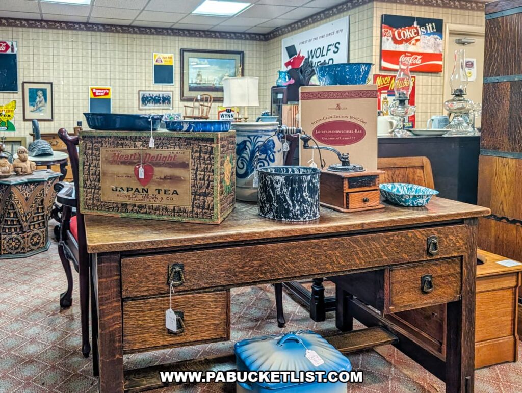 Vintage wooden desk topped with antique kitchenware, tins, and collectibles inside Wagon Wheel Antiques, a multi-dealer antique shop in Butler County, Pennsylvania.
