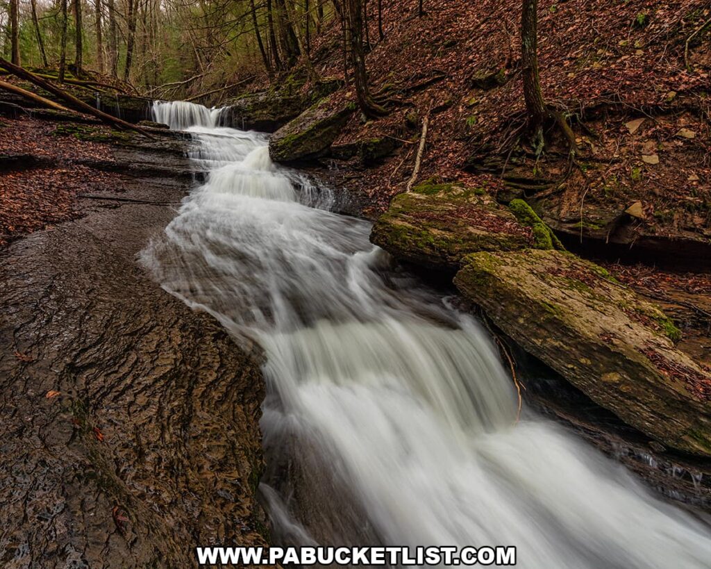 Cascading water flowing over layered rock downstream from Grindstone Falls along an unnamed tributary of Grindstone Run at McConnells Mill State Park in Lawrence County, Pennsylvania.