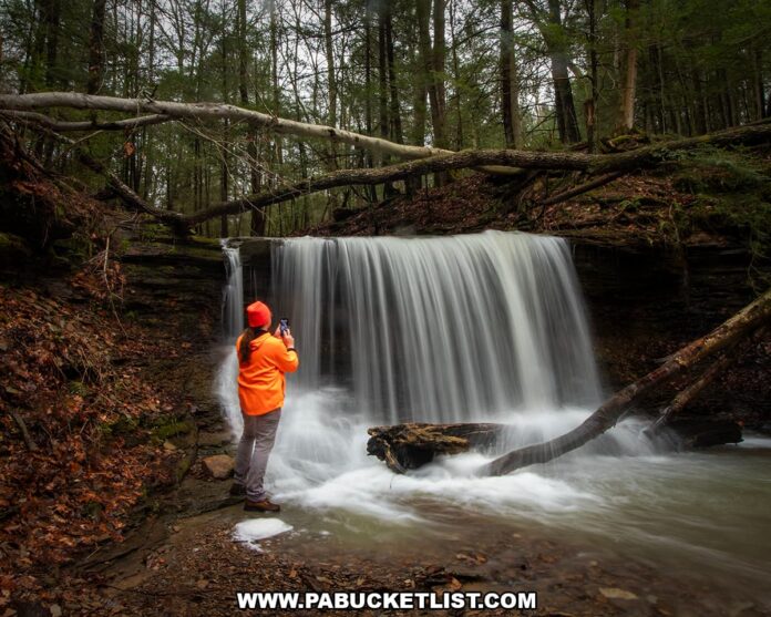 Grindstone-Falls-front-view-self-portrait-McConnells-Mill-State-Park-March-2026 Photographer standing beside Grindstone Falls capturing images of the waterfall along an unnamed tributary of Grindstone Run at McConnells Mill State Park in Lawrence County, Pennsylvania.