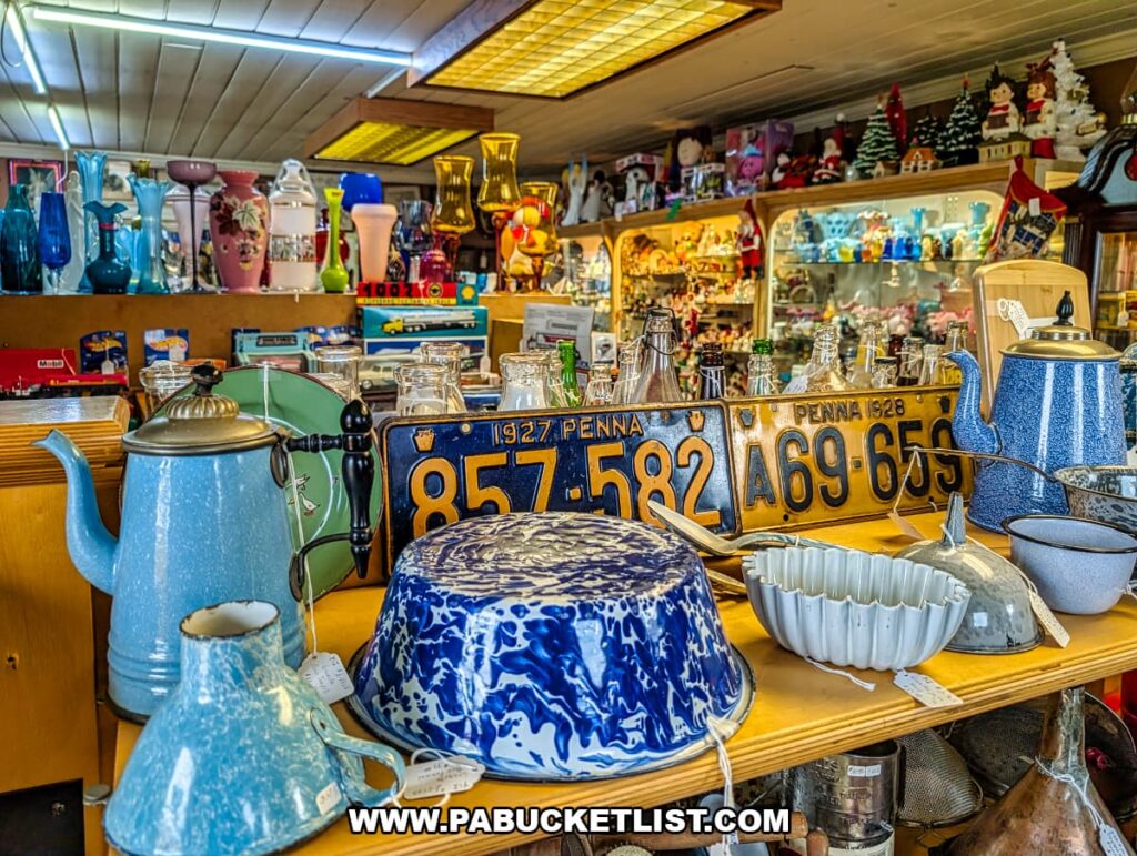 Vintage kitchenware including enamel coffee pots bowls and antique Pennsylvania license plates inside Sugar Grove Antiques in Somerset County PA