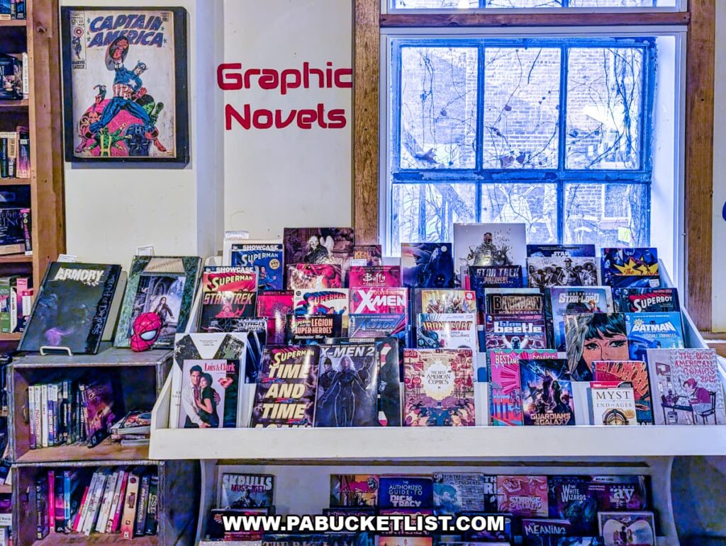 Graphic novels and comic book display at In Between Pages Bookstore in York PA featuring superhero titles and illustrated books on a front table