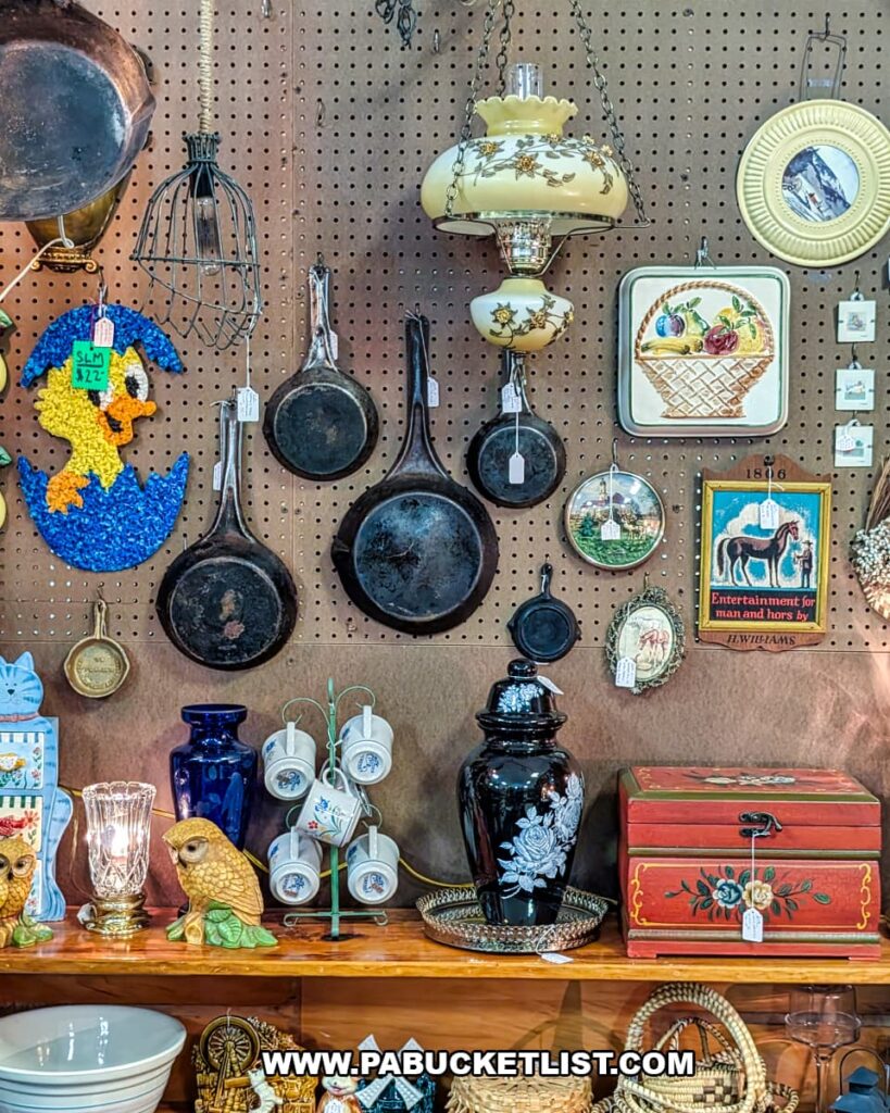 Display of cast iron pans vintage kitchenware lantern and decorative antiques at a vendor booth inside Pen-Mar Antique Market in Waynesboro Pennsylvania