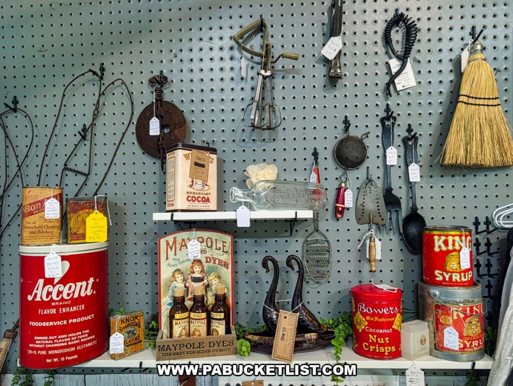 Display of vintage kitchen tools antique advertising tins and household items at a vendor booth inside Pen-Mar Antique Market in Waynesboro Pennsylvania