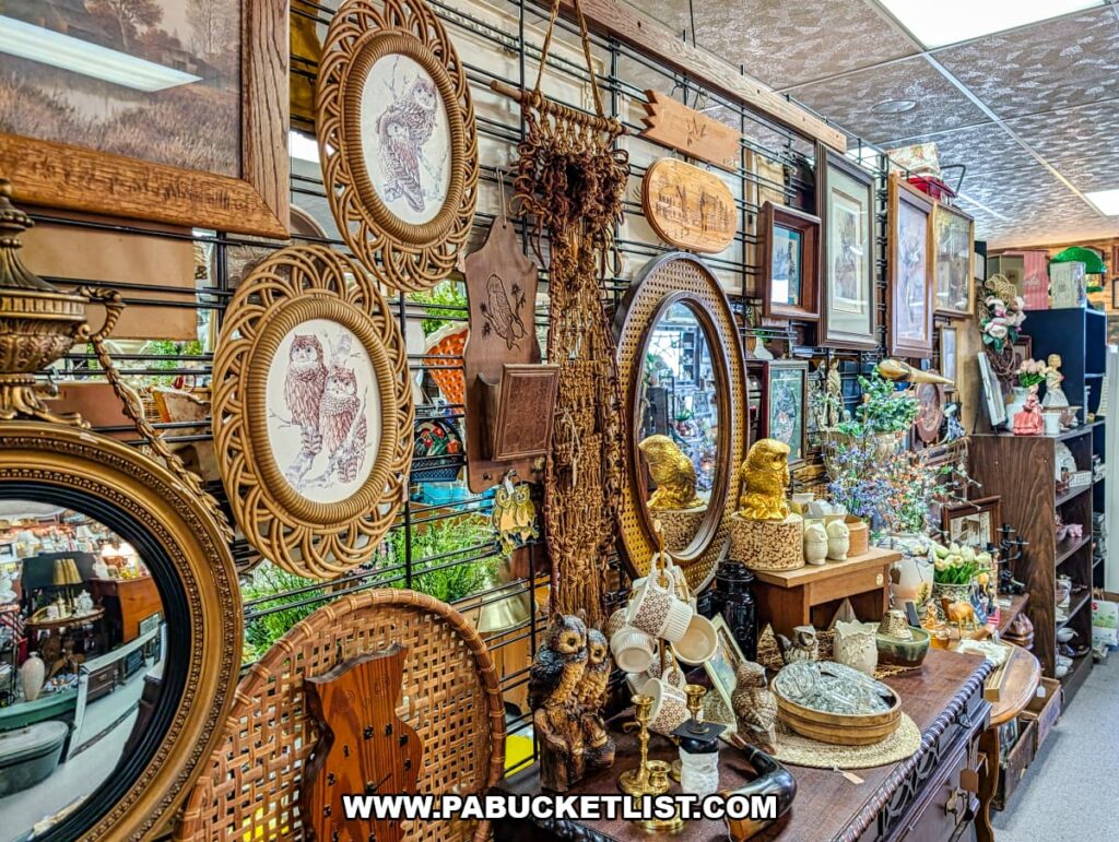 Display of vintage home decor, framed artwork, mirrors, and owl-themed collectibles at Treasure Bin Antiques in Red Lion, York County, Pennsylvania