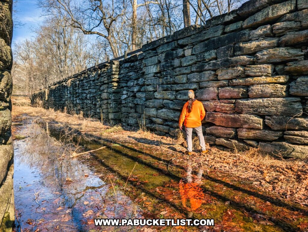 Visitor standing beside the stone walls inside Lock 12 of the historic Susquehanna and Tidewater Canal at the Lock 12 Historic Area in York County, Pennsylvania.