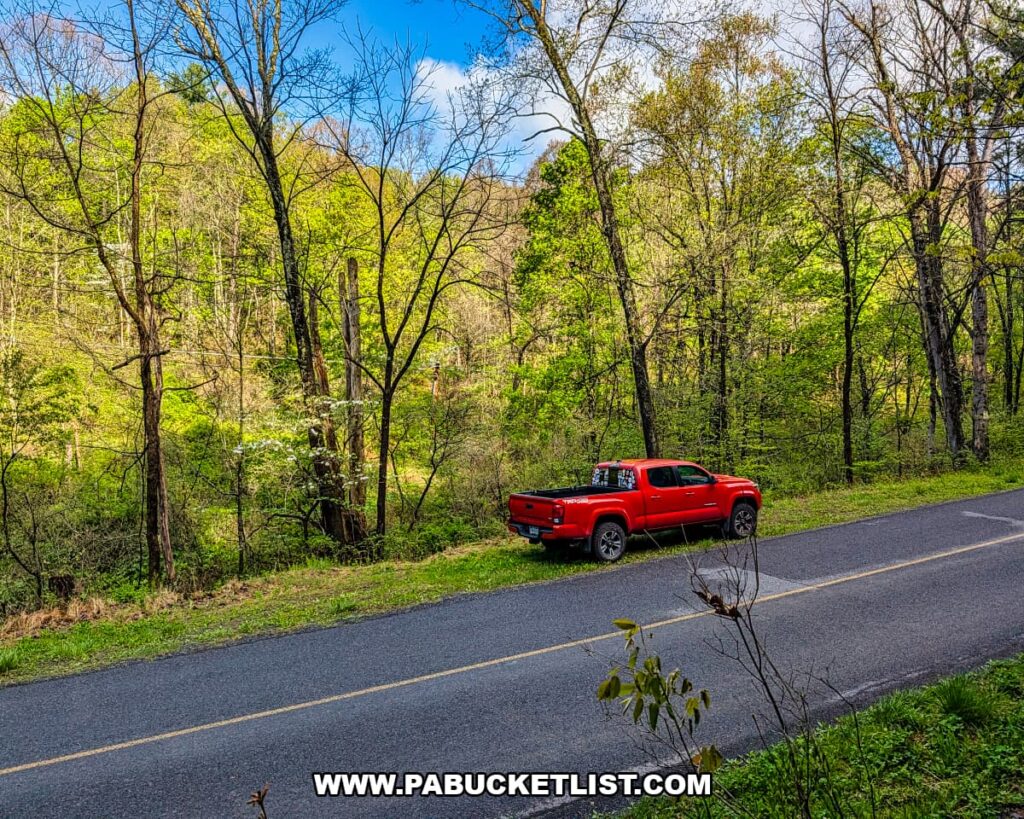 Red pickup truck parked along a quiet road beside spring foliage at Hoverter and Sholl Box Huckleberry Natural Area in Perry County Pennsylvania.