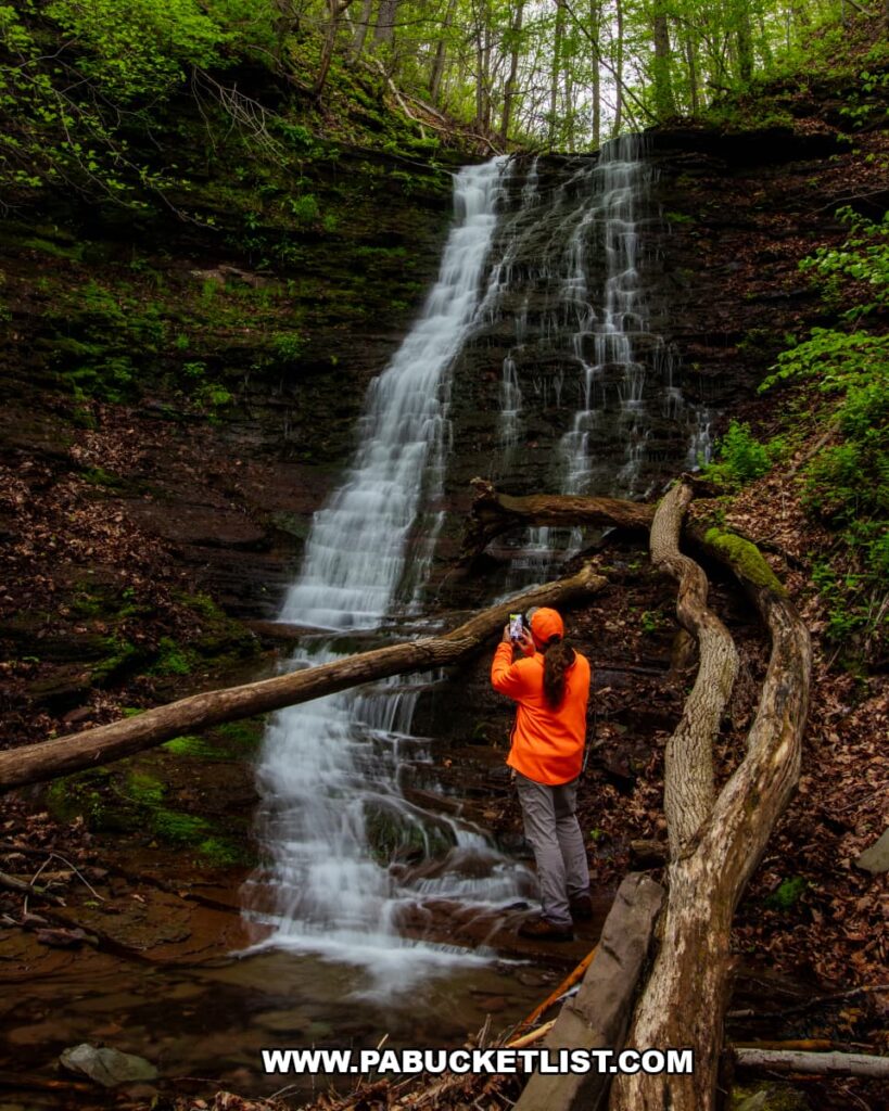 Photographer standing below Rail Island Run Falls along the Pine Creek Rail Trail in Tioga County, Pennsylvania.
