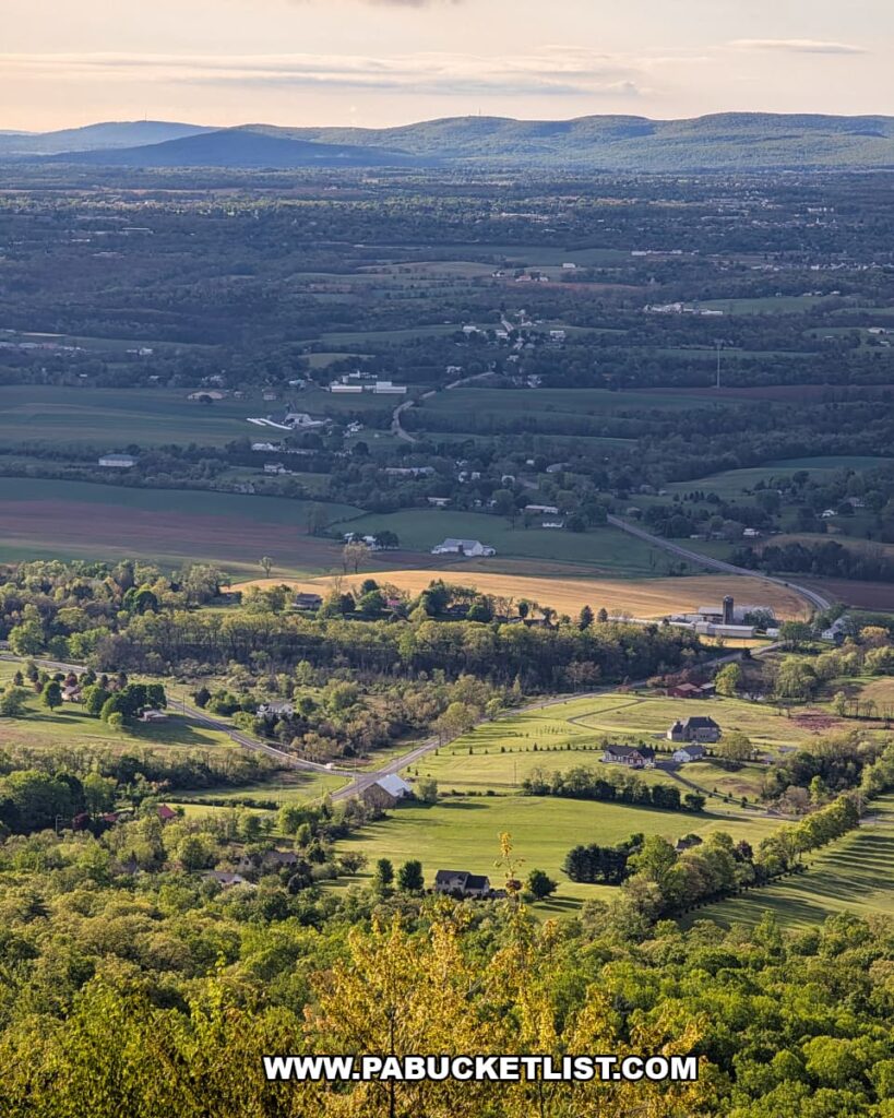 panoramic spring view of farmland and rolling ridges from waggoners gap hawk watch in perry county pennsylvania with sunlit fields below cloudy skies