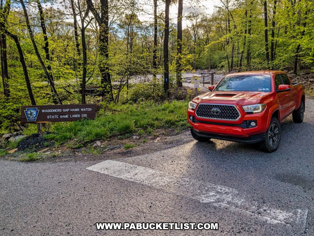 entrance to waggoners gap hawk watch on state game lands 230 in perry county pennsylvania with roadside sign and vehicle parked along forest road