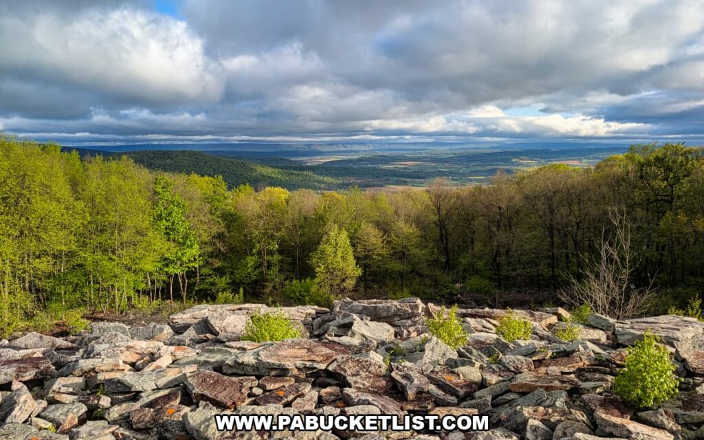 rocky foreground at waggoners gap hawk watch overlooking a vast forested valley and distant ridges in perry county pennsylvania under dramatic clouds
