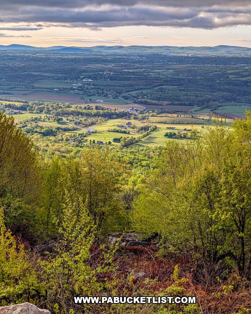 panoramic spring view of farmland and rolling ridges from waggoners gap hawk watch in perry county pennsylvania with sunlit fields below cloudy skies